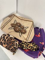 Group shot showing all four items: Nicole Lee purse, Guess leopard clutch, leopard umbrella, purple tote
