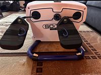 Front view of Scoop Fit trainer showing foot pedals, base, and branding