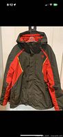 Front view of jacket on hanger showing color blocking and hood