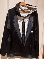 Front view showing tuxedo graphic, pocket, drawstring, visible stain