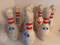 Front angled view of all eight pins showing logos and overall wear