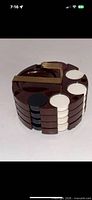 Brown bakelite chip rack loaded with black and white chips, brass locking clip installed