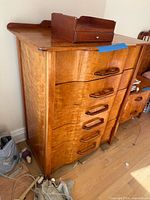 Left-side view of one dresser showing drawer fronts, handles, cherry grain