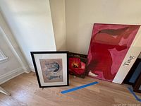 Group view of three framed artworks: abstract print, floral painting, red bear poster