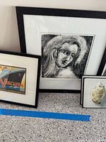 Three framed artworks side by side on countertop