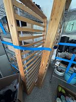 Two wooden bed frames with slatted sections secured together