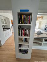 Full built-in shelf showing four tiers of assorted books