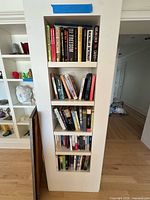Full height view of built-in shelf containing three shelves of books