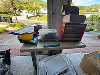 Wide view of table showing starter kit box, clear component box, red drawer organizer and trays of parts