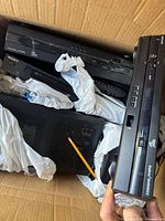 Open box showing several stacked AV components, including Sony device and VHS recorder