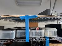 Wire shelf with three clear drawers, grey plastic tool case, flat boards