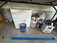 Overall lot under shelf showing all paint and sealer containers