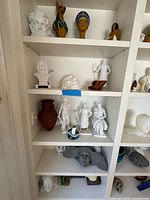 Shelved collection showing multiple 3D printed sculptures and figures