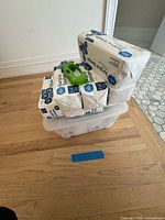 Stack of four sealed surgical sponge packs on clear tote