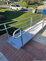 Full view of assembled aluminum wheelchair ramp with handrails