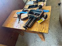 Workbench top with cross-slide vise, pliers, soldering iron, belt, hardware