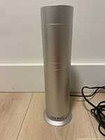 Full view of silver cylindrical diffuser standing upright
