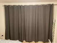 Curtains hung on rod showing color, fabric and grommets
