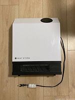 Front view of Heat Storm wall heater with power cord