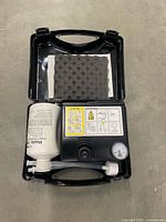 Open case showing compressor, sealant bottle, hose and foam insert