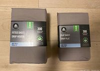 Two packaged Hometrends queen sheets side by side