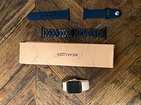 Apple Watch with pink band, Wearlizer box, blue silicone strap, black/blue link bracelet