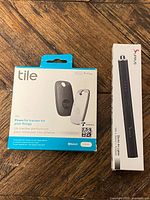 Front view of boxed Tile Pro 2-pack and SUPRUS lighter box