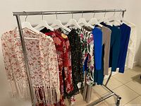 Front view of clothing rack showing nine dresses of various patterns and colours