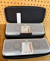Two Logitech MM50 speaker docks, one inside carry case, remote visible