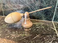 Side view showing glass base, metal head, rubber bulb and metal wand