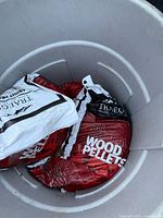 Two Traeger pellet bags in plastic bin, showing labels