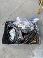 Top view of tote showing assorted black cables, zip-lock bags with smaller cords and connectors