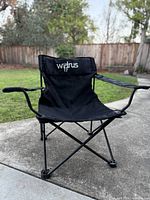 Front view of black Walrus folding camp chair on patio