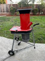 Side view of red Chipper Chopper on stand