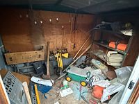 Overall interior of shed showing tools, wagon, shelving, shop vacuum, gas can
