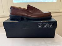 Side view of one loafer on top of original box