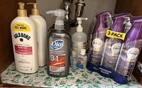 All containers set under sink: Febreze 3-pack, two Gold Bond lotions, Dial Men wash, two 3M Avagard sanitizers