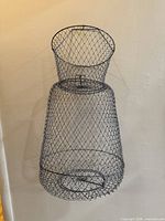Front view of wire mesh fish basket hanging against wall