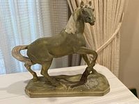 Full view left side of horse sculpture showing base and stance