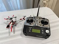 Futaba T7C transmitter beside mini helicopter, overall view