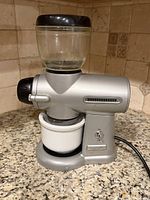 Front view of KitchenAid Pro Line burr grinder showing hopper, body, ceramic bin and power cord