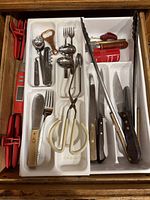 Full drawer view showing utensils, knives, tongs, gadgets