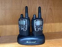 Front view of two Midland X-Talker radios seated in charging cradle