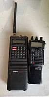 Front view showing both handheld scanner radios with antennas and keypads