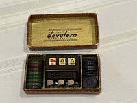 Open box showing Brodi miniature slot machine, chip stacks and token