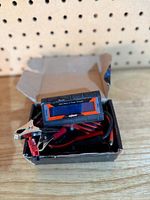 meter inside open box with leads and clips visible