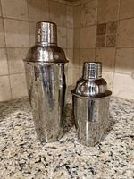 Front view of both hammered stainless steel cocktail shakers showing size difference