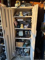 Full view of cabinet doors open showing shelves packed with electronics