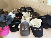 All hats laid out on table showing logos and types