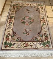 Full view of rug showing border, field, motifs and fringe